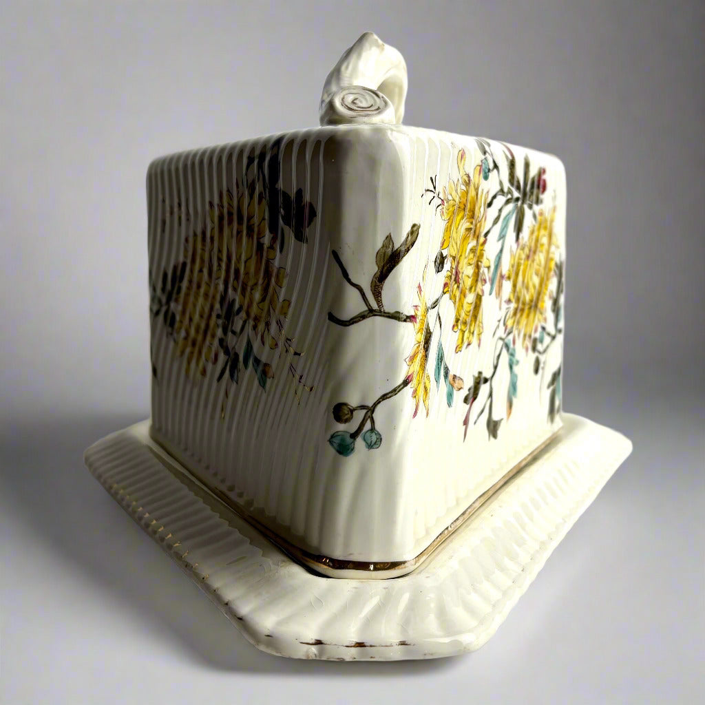 Ceramic butter dish with floral design on a gray background