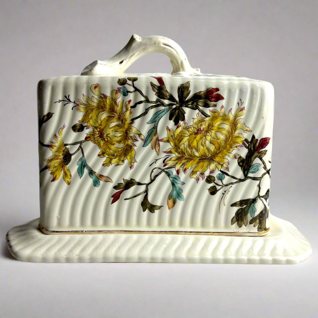 Decorative ceramic butter dish with floral design on a white background
