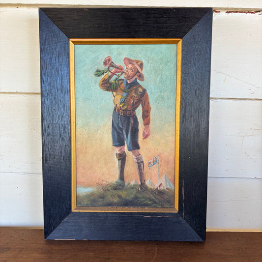 Framed artwork of a boy with a horn on a wooden surface