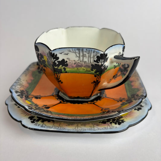 Decorative teacup and saucer with nature-themed design on a white background