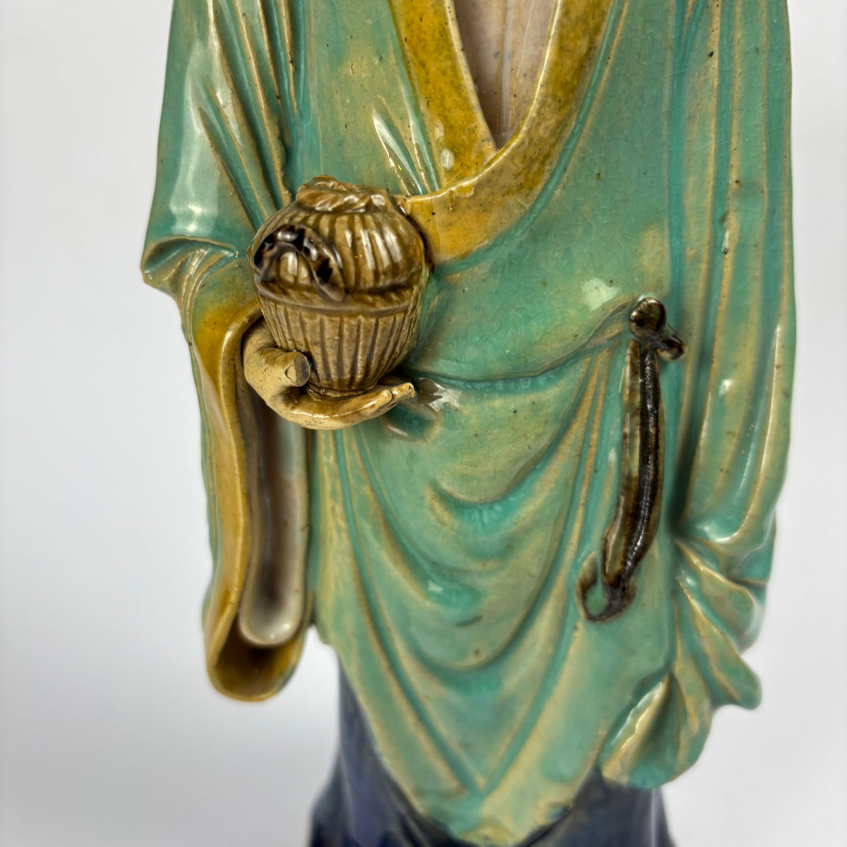 Detail of robe and held vessel