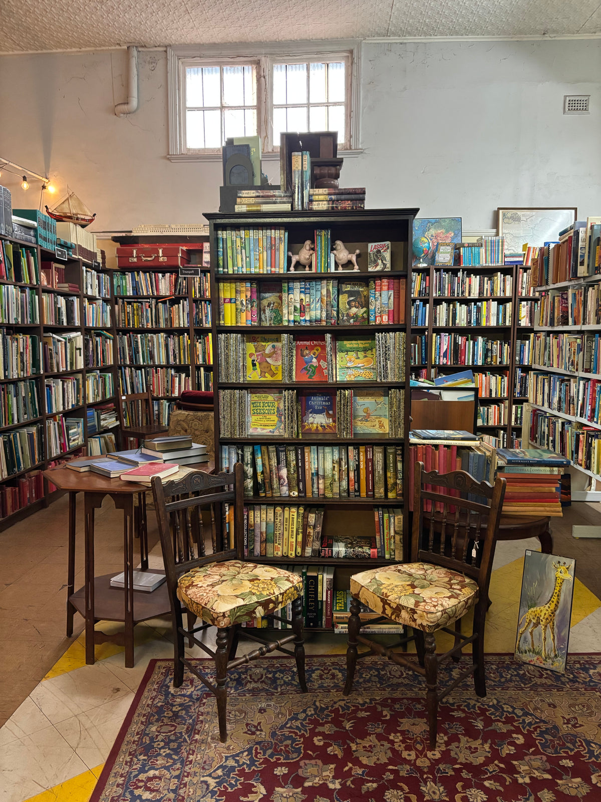 Bookshelves and vintage upholstered chairs inside the shop