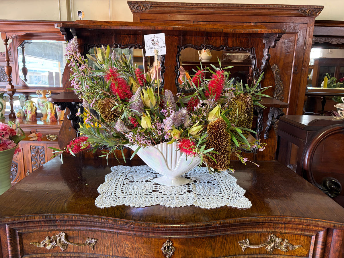 Native flower arrangement by Thistle & Bloom in a white vase on an antique timber sideboard at Northam Secondhand