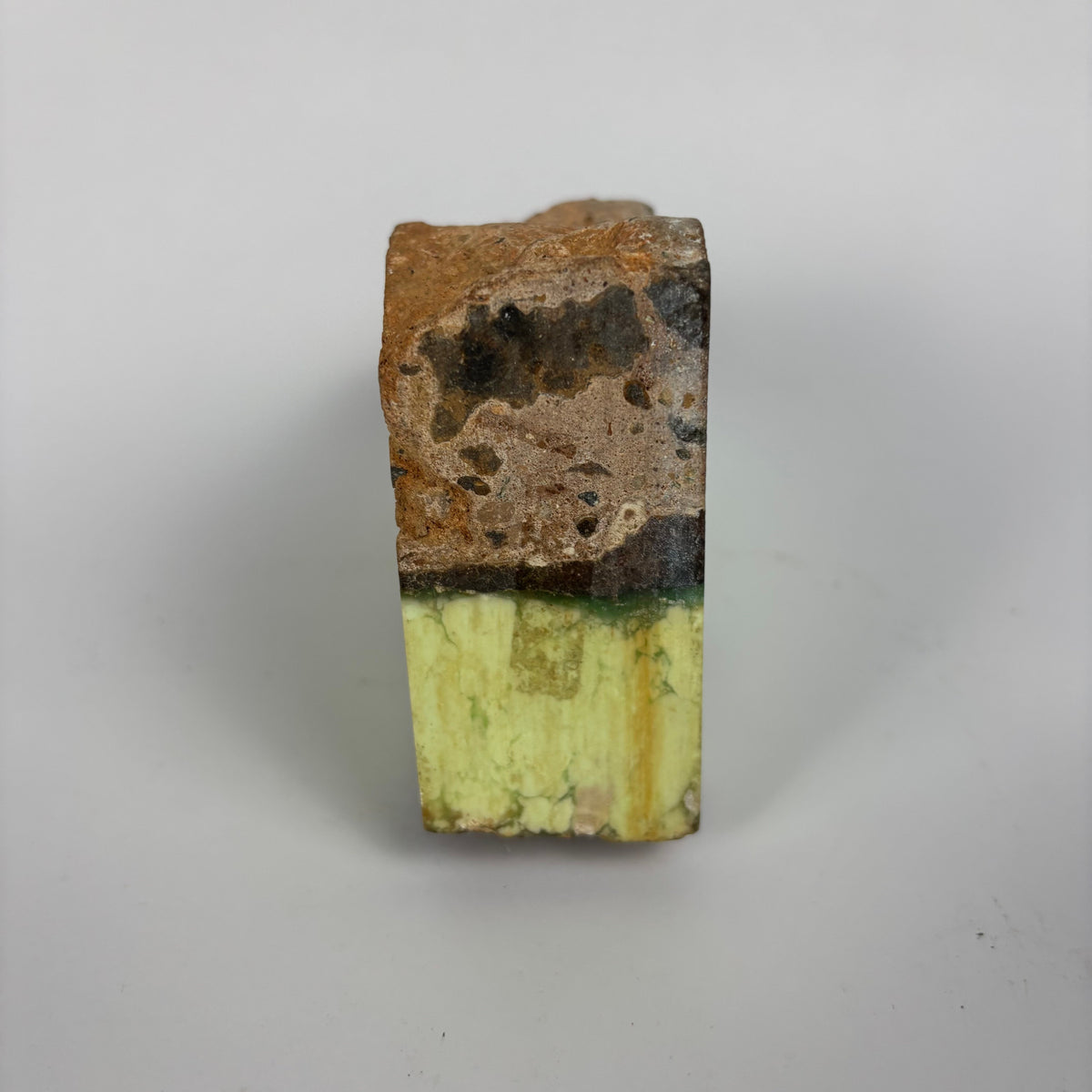 Rough pale yellow-green mineral seam in brown host rock specimen