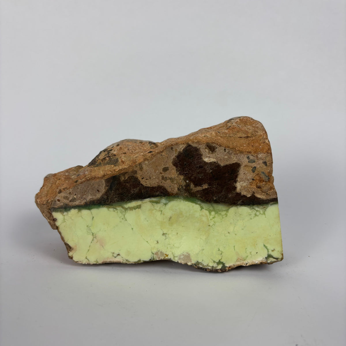 Rough pale yellow-green mineral seam in brown host rock specimen