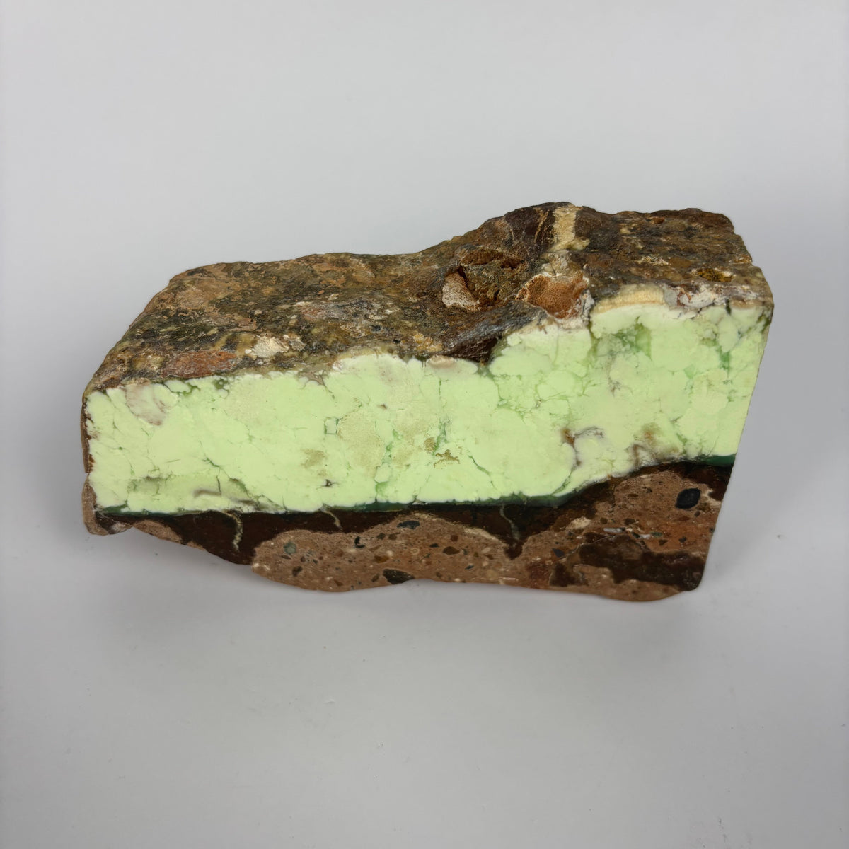 Rough pale yellow-green mineral seam in brown host rock specimen