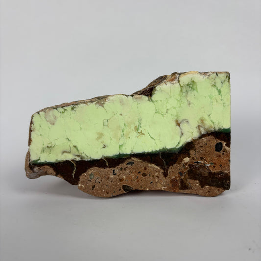 Rough pale yellow-green mineral seam in brown host rock specimen