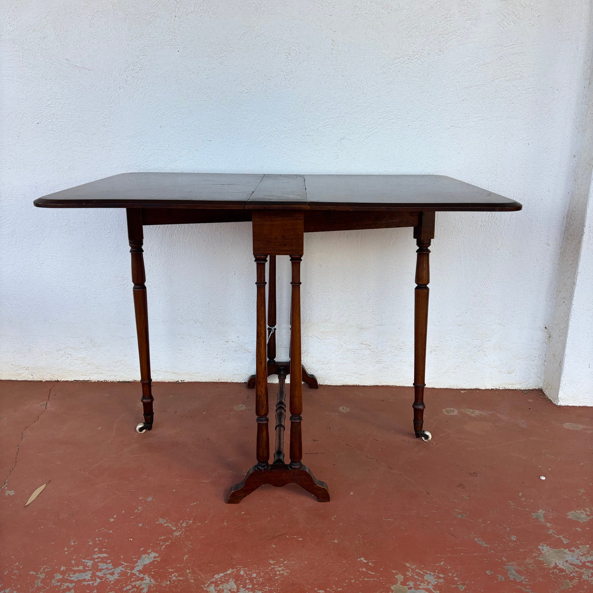 Antique timber drop-leaf table shown extended