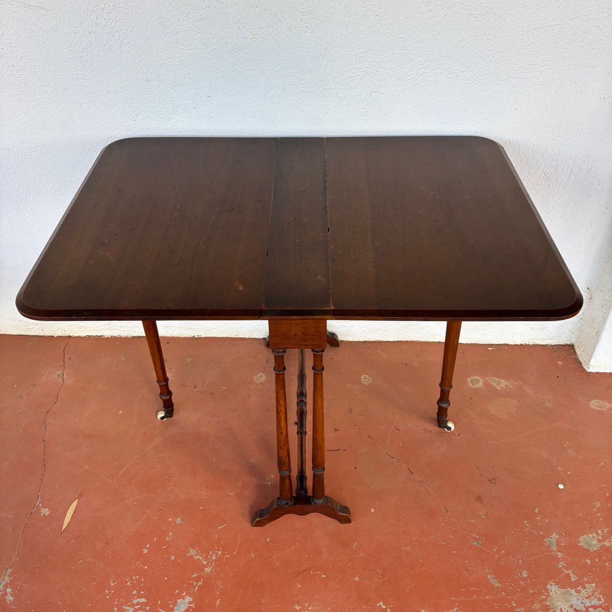 Antique timber drop-leaf table shown extended