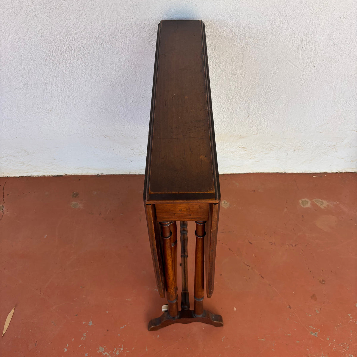 Antique timber drop-leaf table shown folded